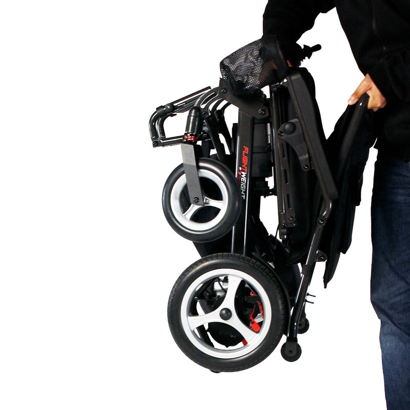 Person lifting the folded Travel Buggy DASH 3 electric wheelchair
