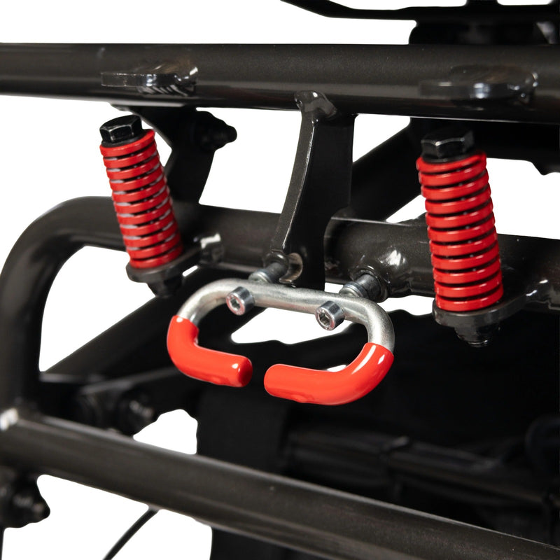 Close-up of the Travel Buggy DASH 3 folding frame locking mechanism with red springs and handle