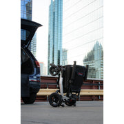 Travel Buggy Grand Tourer folded and standing beside an SUV